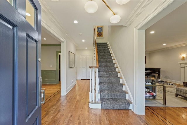 foyer entrance featuring ornamental molding and hardwood / wood-style floors