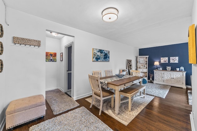 dining space with dark wood-type flooring and baseboards