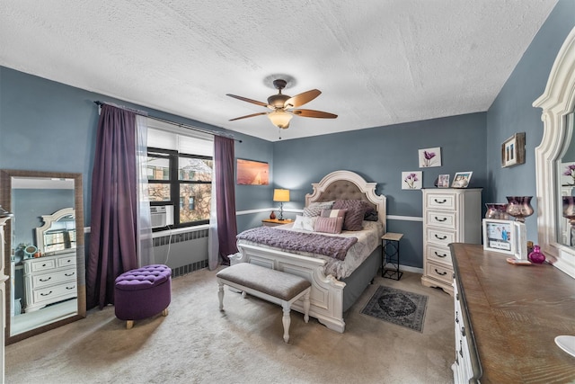 bedroom featuring radiator heating unit, a textured ceiling, a ceiling fan, and carpet flooring