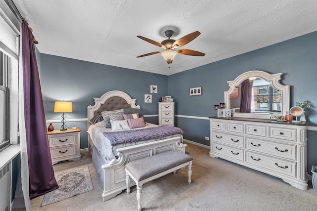 bedroom with light carpet, ceiling fan, a textured ceiling, and baseboards