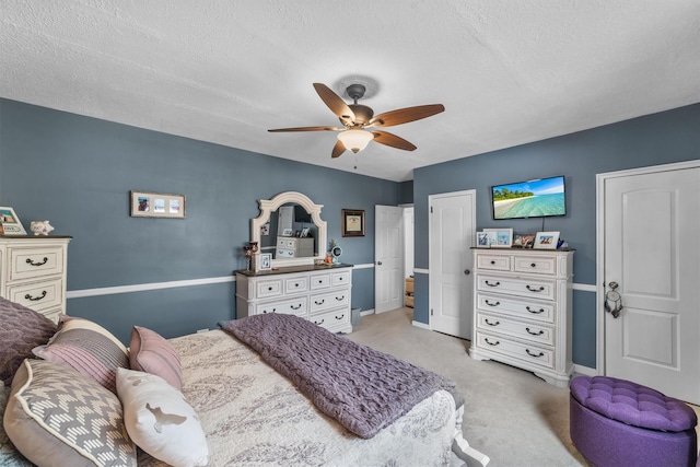 bedroom with light carpet, ceiling fan, baseboards, and a textured ceiling