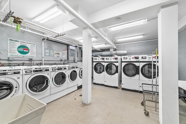 shared laundry area featuring light floors and washing machine and clothes dryer