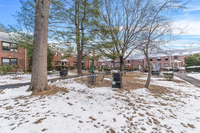 snowy yard featuring a residential view