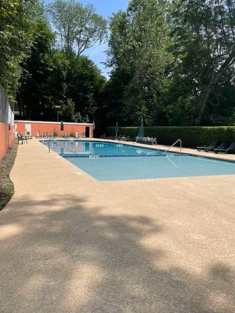 pool with a patio and fence