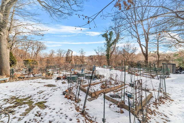 yard covered in snow with a garden and fence