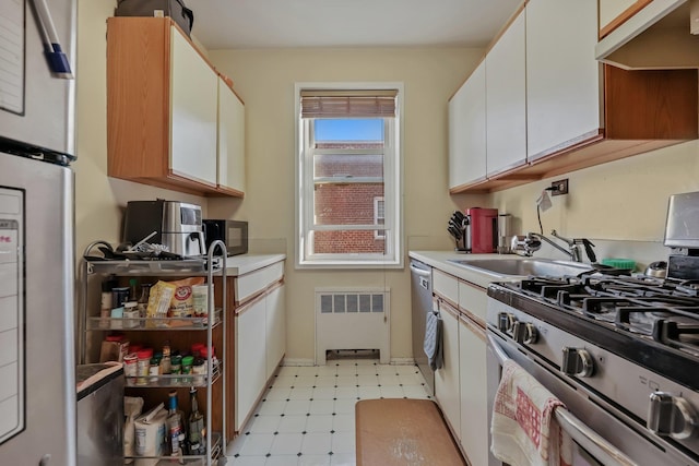 kitchen with white cabinetry, sink, radiator, and appliances with stainless steel finishes