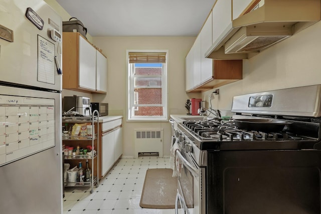 kitchen featuring white cabinetry, radiator, stainless steel gas range, and fridge