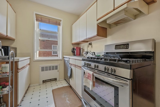 kitchen with stainless steel appliances, white cabinetry, radiator, and sink