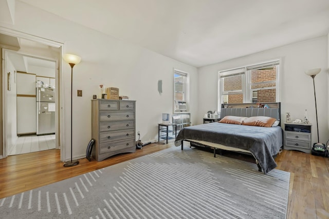 bedroom featuring stainless steel refrigerator and hardwood / wood-style floors