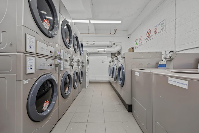 laundry area featuring stacked washer and clothes dryer, light tile patterned floors, and independent washer and dryer