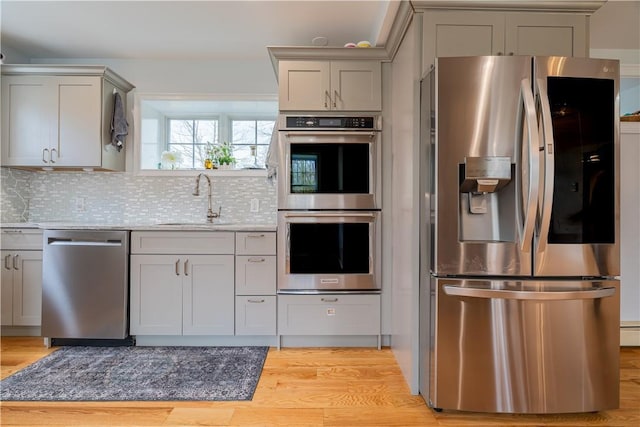 kitchen featuring sink, decorative backsplash, gray cabinets, and stainless steel appliances