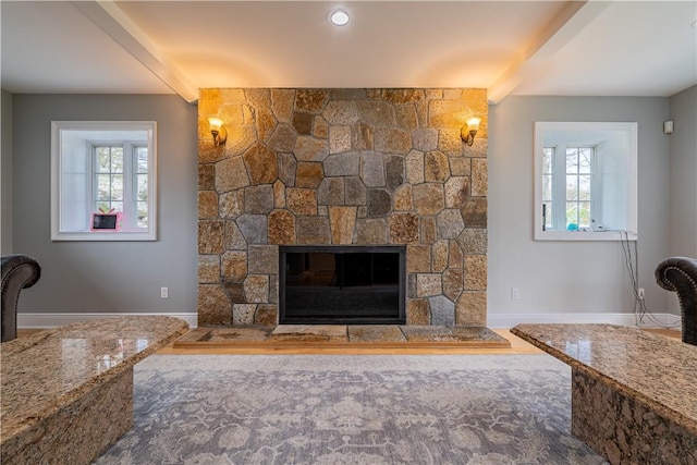 unfurnished living room featuring beam ceiling and a fireplace