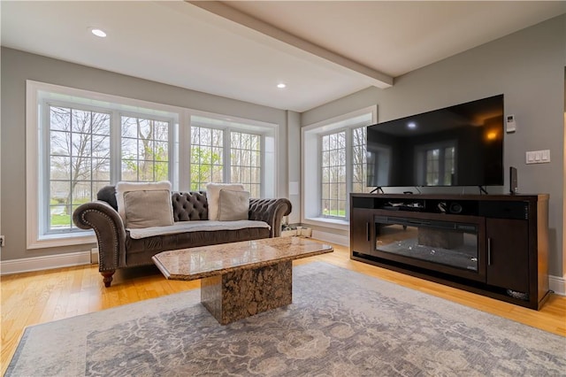 living room with beam ceiling and light hardwood / wood-style flooring