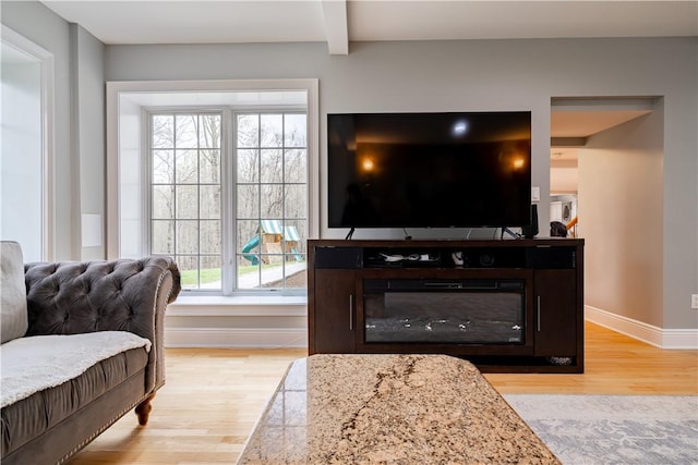 living room with beamed ceiling and light hardwood / wood-style flooring