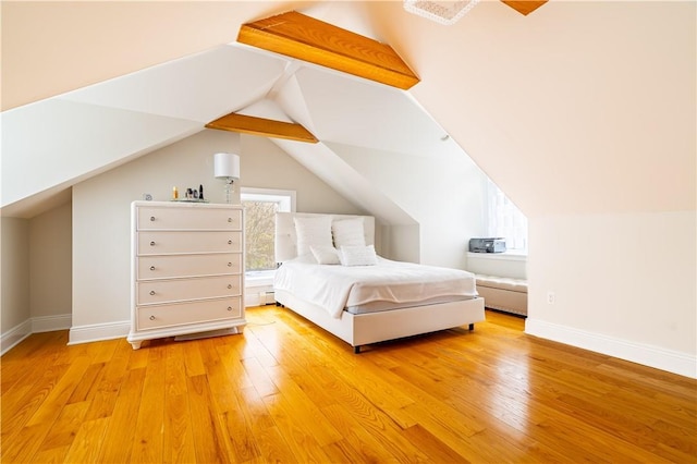 unfurnished bedroom featuring vaulted ceiling and light wood-type flooring