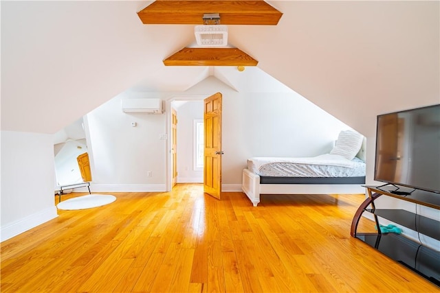 bedroom featuring an AC wall unit, lofted ceiling, and light hardwood / wood-style floors