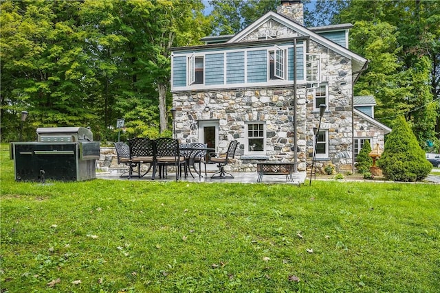 rear view of house with a lawn and a patio