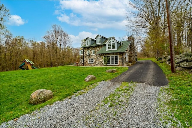 view of front of home featuring a front lawn and a playground