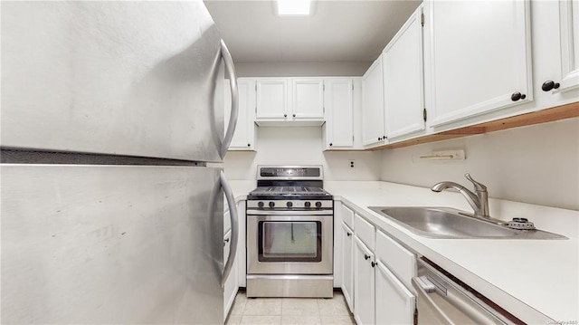 kitchen featuring white cabinetry, appliances with stainless steel finishes, sink, and light tile patterned floors