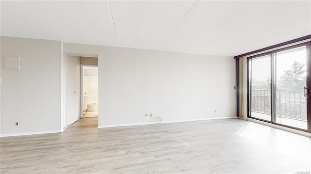 empty room featuring a wall of windows and light wood-type flooring