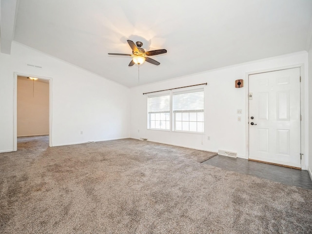 unfurnished living room with dark colored carpet, lofted ceiling, and ceiling fan