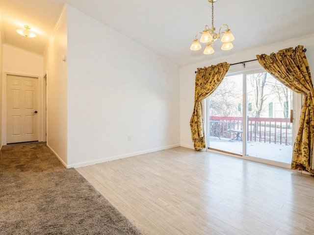 spare room featuring an inviting chandelier, ornamental molding, and light hardwood / wood-style floors