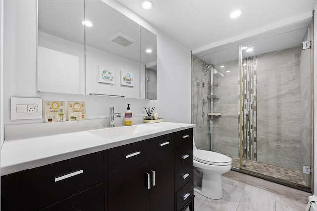 bathroom featuring vanity, toilet, and a shower with shower door