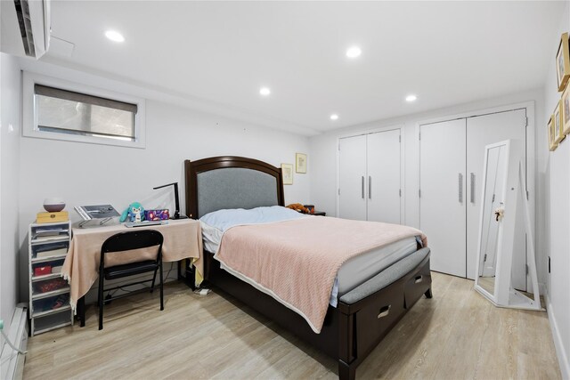 bedroom featuring multiple closets and light hardwood / wood-style floors