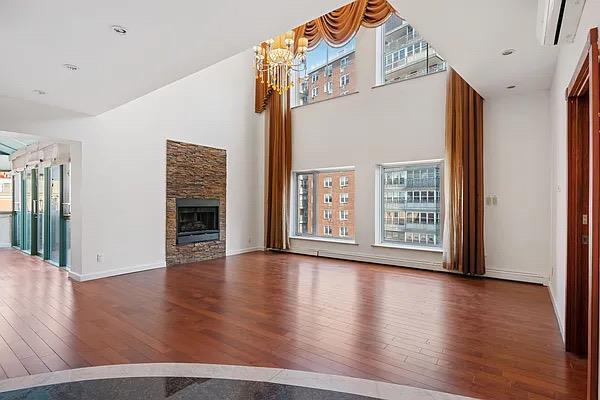 unfurnished living room featuring dark hardwood / wood-style floors, a chandelier, and a fireplace