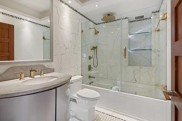 full bathroom featuring vanity, enclosed tub / shower combo, and toilet