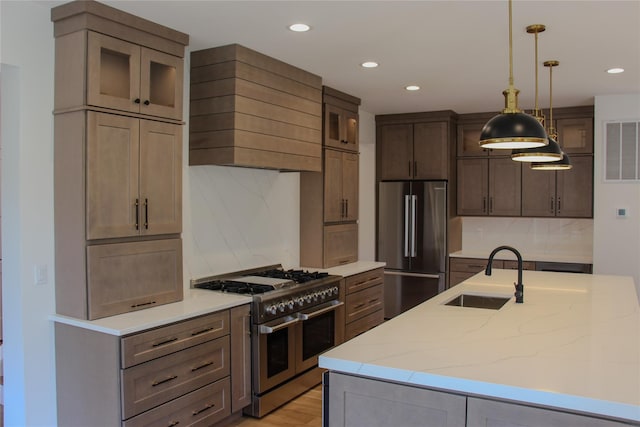 kitchen featuring sink, appliances with stainless steel finishes, hanging light fixtures, light stone countertops, and custom exhaust hood