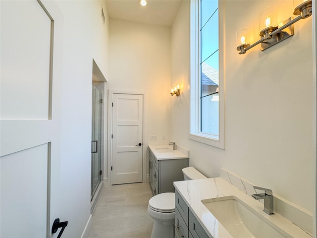 bathroom featuring walk in shower, vanity, toilet, and tile patterned flooring