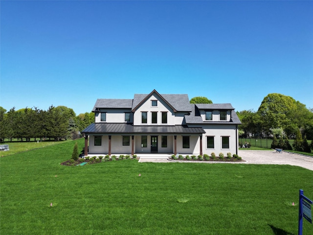2045 Willow Dr, East Marion, NY 11939 - modern inspired farmhouse featuring a standing seam roof, gravel driveway, a porch, stucco siding, and metal roof