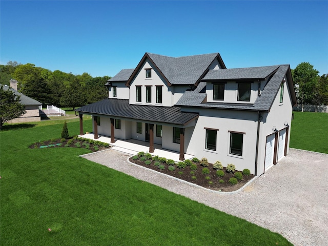 2045 Willow Dr, East Marion, NY 11939 - modern farmhouse style home with an attached garage, a standing seam roof, covered porch, gravel driveway, and stucco siding