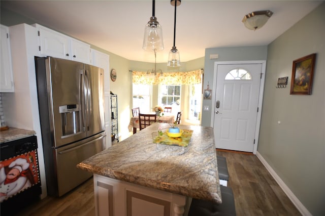 kitchen featuring white cabinetry, decorative light fixtures, stainless steel fridge with ice dispenser, and a kitchen island