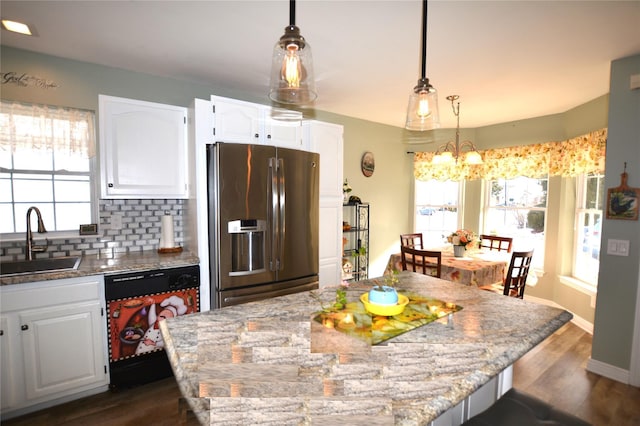 kitchen with white cabinetry, dishwasher, sink, light stone counters, and stainless steel refrigerator with ice dispenser