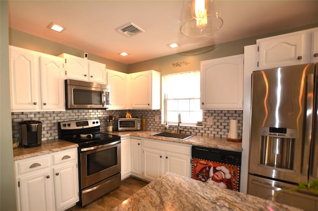 kitchen with sink, white cabinetry, light stone counters, tasteful backsplash, and appliances with stainless steel finishes