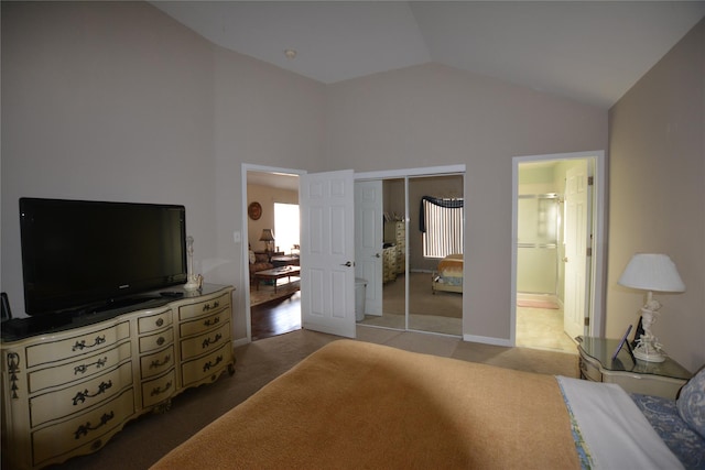 bedroom with lofted ceiling, carpet floors, ensuite bath, and a closet