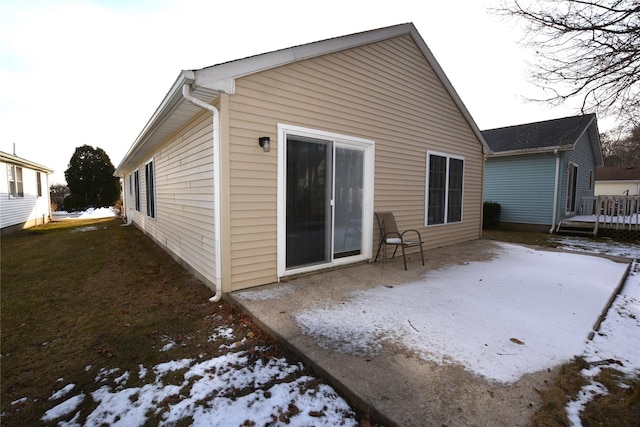 view of snow covered back of property