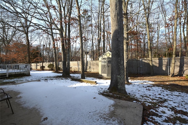 yard covered in snow featuring a storage unit