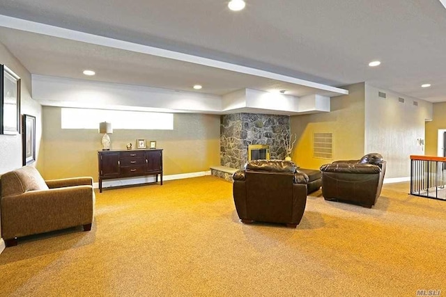 carpeted living room featuring a stone fireplace