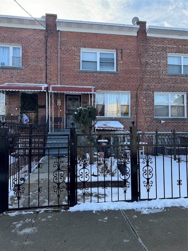 view of property with a fenced front yard and brick siding