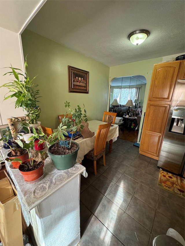 dining area with dark tile patterned floors and a textured ceiling