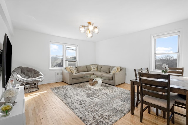 living room featuring radiator, light hardwood / wood-style floors, and a healthy amount of sunlight