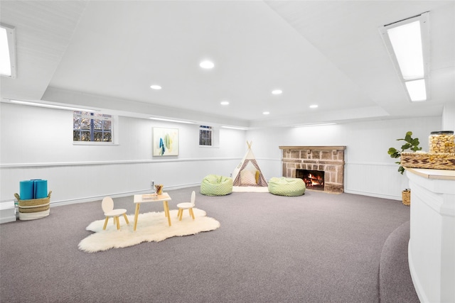 recreation room featuring recessed lighting, carpet, and a stone fireplace