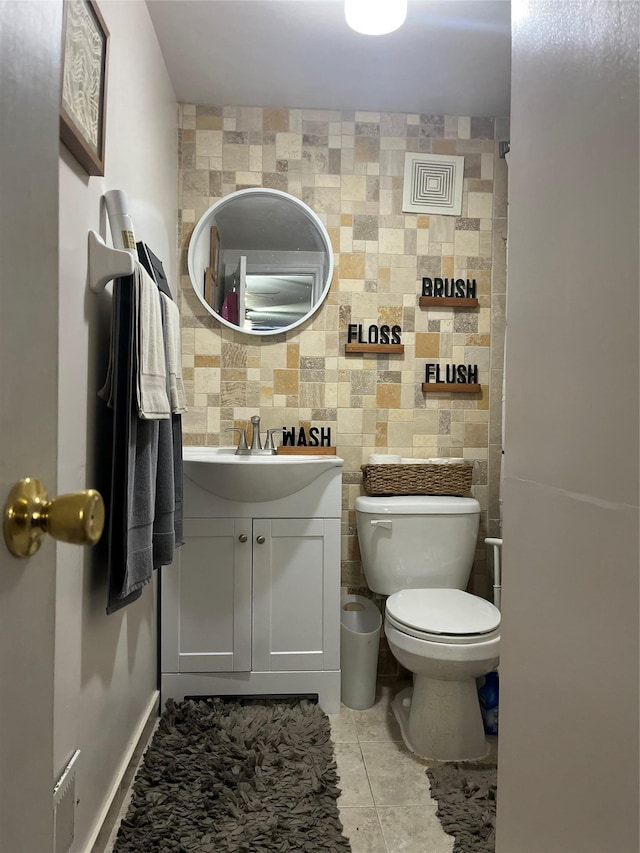 bathroom with vanity, toilet, tile patterned flooring, and tile walls