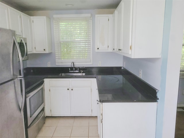 kitchen featuring white cabinetry, sink, light tile patterned floors, and stainless steel appliances