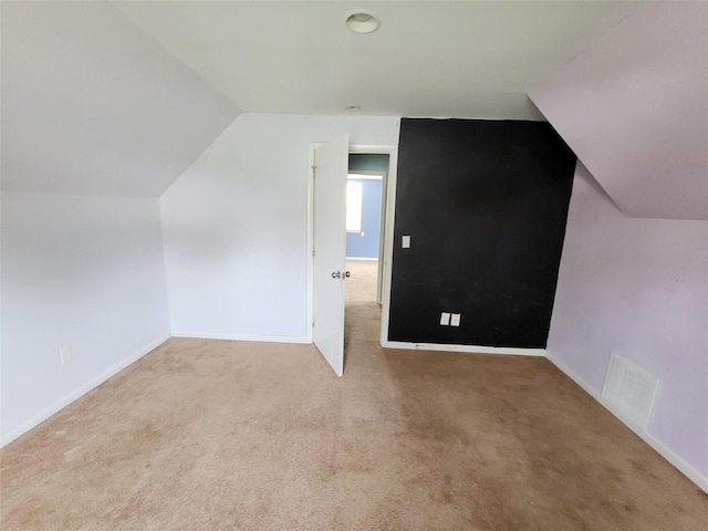 bonus room featuring vaulted ceiling and carpet