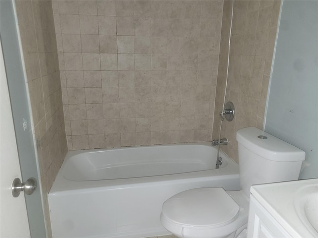 full bathroom with tiled shower / bath, vanity, and toilet