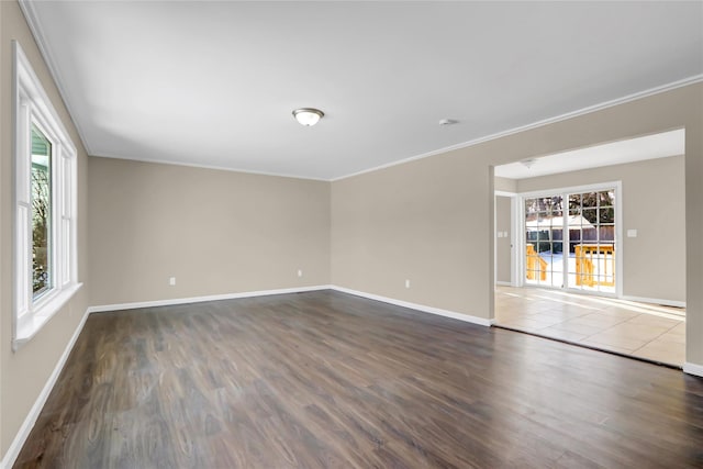 unfurnished room with crown molding, a healthy amount of sunlight, and dark hardwood / wood-style flooring